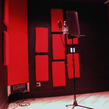 Microphone set up against red and black acoustic treatment in Studio A